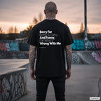 SORRY FOR BEING SO SEXY AND FUNNY, IDK WHAT’S WRONG WITH ME – schwarzes Oversize T-Shirt mit weißem Backprint, Herren im Skatepark
