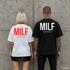 MILF – Oversize Shirt mit Spruch auf dem Rücken, Paar in Weiß und Schwarz vor Betonwand