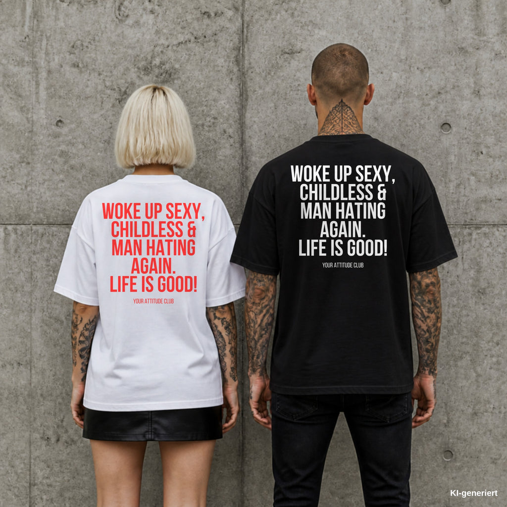 WOKE UP SEXY, CHILDLESS & MAN HATING AGAIN. LIFE IS GOOD! – Oversize Shirt mit Spruch auf dem Rücken, Paar in Weiß und Schwarz vor Betonwand